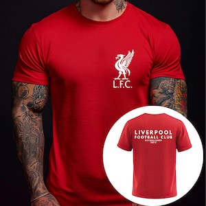 May include: A red short-sleeved t-shirt featuring a white Liverpool Football Club crest on the left chest. An inset circle shows the back of the shirt with the white text LIVERPOOL FOOTBALL CLUB ESTABLISHED 1892 printed in the centre.