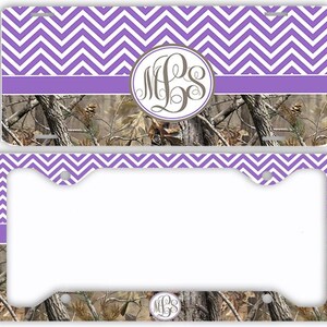 May include: A license plate and license plate frame with a purple and white chevron pattern. The top of the plate and frame have the chevron pattern. The bottom of the plate and frame have a camouflage pattern. A monogram is in the center.