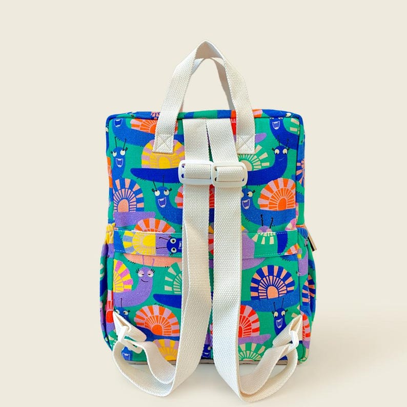 Back view of colorful snail-print kids backpack showing adjustable white straps and sturdy design - comfortable and playful for little explorers.