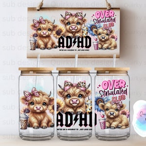 Op de afbeelding: Drie glazen bekers van 473 ml met een houten deksel en rietje. Elke beker heeft een cartoon Highland-koe met een roze strik en een zonnebloem. De bekers hebben de tekst "Over Stimulated Club" en "AD/HD We're on a highway to... hey look, cows!" erop gedrukt.