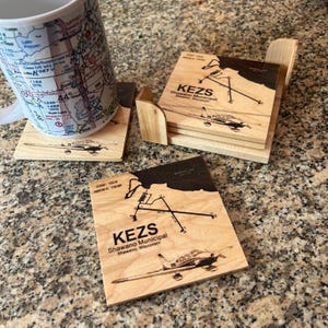 Porta-copos de madeira gravados com tema de aviação, personalizados com diagramas de aeroportos.