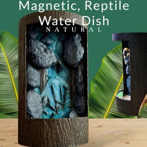 Puede incluir: Un bebedero para reptiles con un diseño natural. El recipiente es cilíndrico con un exterior marrón texturizado. En el interior, hay un elemento acuático azul con rocas de color gris oscuro. El texto "Magnetic, Reptile Water Dish NATURAL" está en la parte superior.