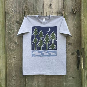 May include: A heather grey t-shirt with a blue and green graphic print of a forest scene with a crescent moon and moose running through the trees.