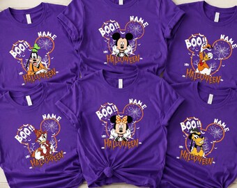 May include: Six purple short-sleeve t-shirts featuring various Disney characters in Halloween costumes. Each shirt displays a Mickey Mouse ear silhouette with a spiderweb, the text BOO!! and HALLOWEEN, and a placeholder for a name.
