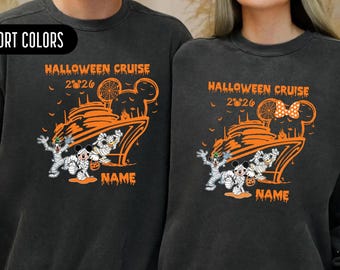 May include: Two charcoal gray crewneck sweatshirts featuring an orange graphic print. The design includes a cruise ship, mummy-wrapped cartoon characters, the text HALLOWEEN CRUISE 2026, and a placeholder for a name. The fabric has a vintage wash.