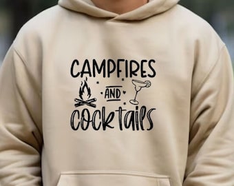 May include: A beige hoodie with a black graphic that says "Campfires and Cocktails" with a campfire and a cocktail glass icon.