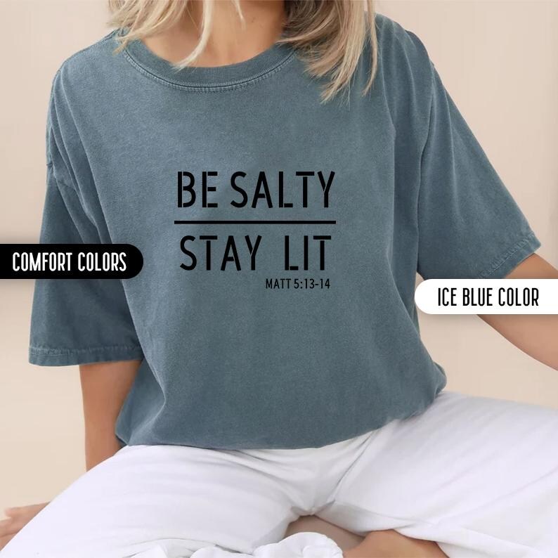 May include: A blue t-shirt with the text "BE SALTY STAY LIT" and the scripture reference "MATT 5:13-14".