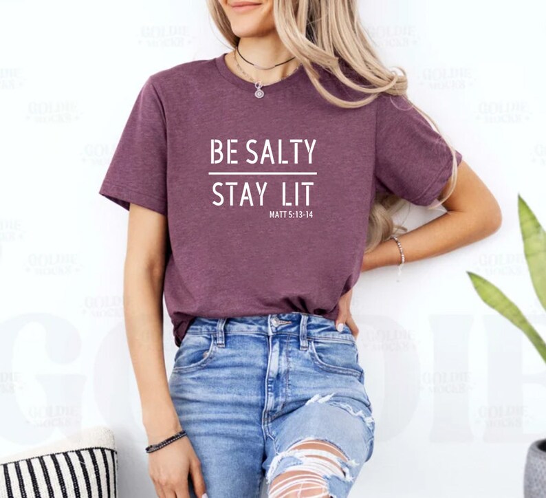 May include: A maroon t-shirt with the text "BE SALTY STAY LIT" and the scripture reference "MATT 5:13-14" in white.