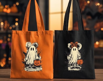 May include: Two canvas tote bags, one orange and one black, each featuring a graphic print of a ghost character with mouse ears holding a small jack-o'-lantern bucket. The orange bag displays a ghost with round ears, while the black bag shows a ghost with a polka-dot bow on its head.