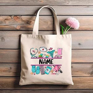May include: A white canvas tote bag with a pink, blue, and green design featuring a nurse's hat, stethoscope, pills, and other medical symbols. The text "NAME" is printed in pink on the bag.