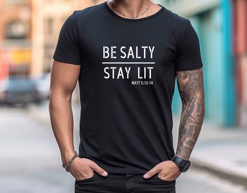 May include: Black t-shirt with white text that reads "BE SALTY STAY LIT" and "MATT 5:13-14"