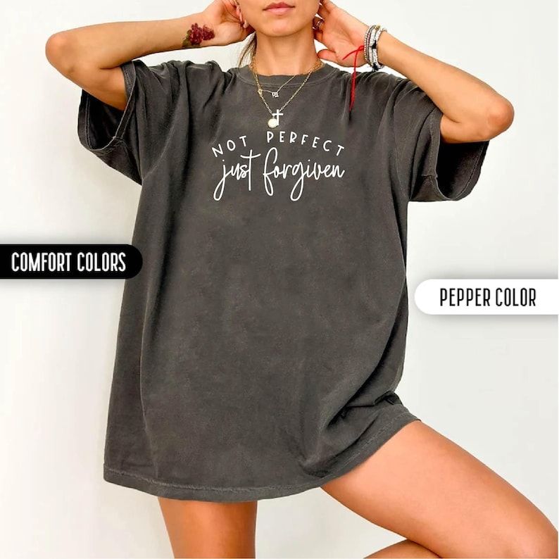 May include: Pepper-colored t-shirt with the text "NOT PERFECT just forgiven" in white script. The shirt is a Comfort Colors brand. The image also includes the text "COMFORT COLORS" and "PEPPER COLOR".