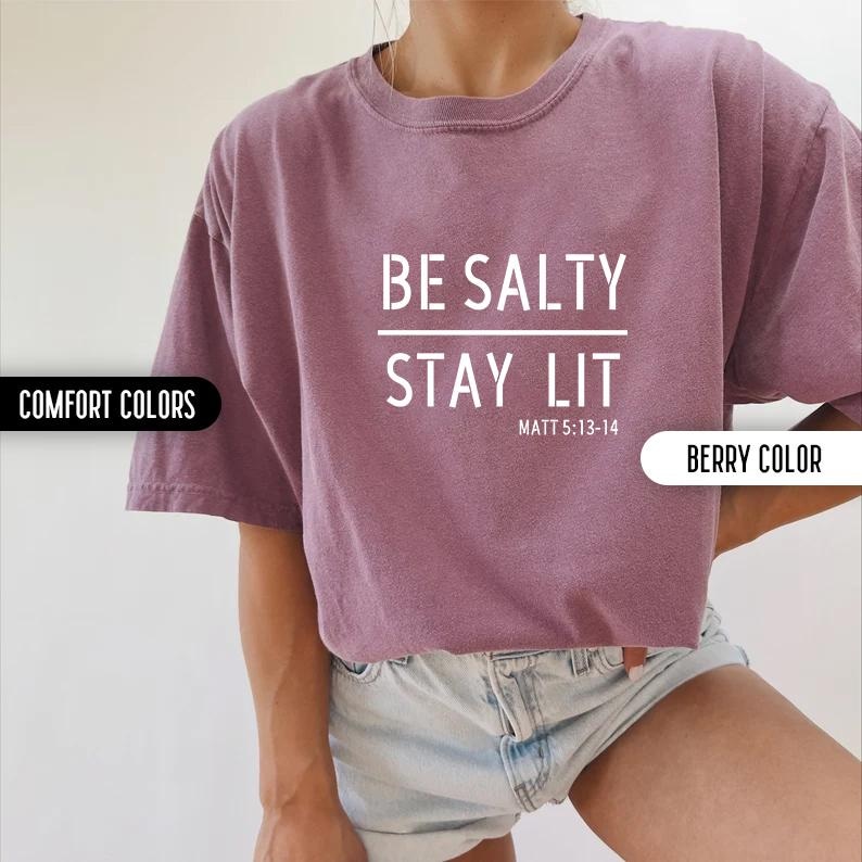 May include: A purple t-shirt with the text "BE SALTY STAY LIT" and the scripture reference "MATT 5:13-14" in white text.