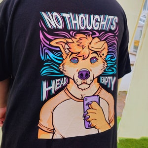 May include: Black t-shirt featuring a colourful graphic of a cartoon dog holding a phone. The text "NO THOUGHTS HEAD EMPTY" is printed on the shirt.