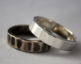 May include: Two hammered metal rings, one silver and one bronze, stacked on top of each other.