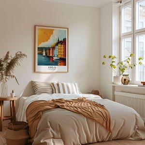 a cozy bedroom with a large bed, a framed poster of a scenic view, and various decorative elements such as a potted plant and a vase.