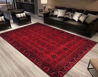 May include: A red and black patterned rug with a geometric design. The rug has a dark border with a wavy pattern.