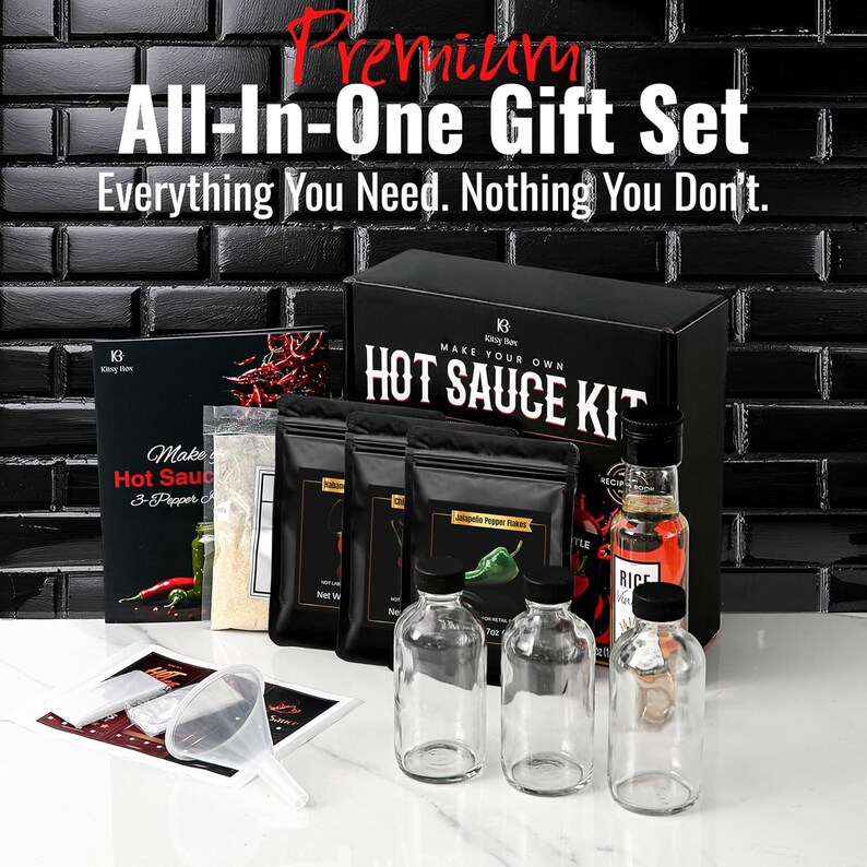 May include: A black gift set labeled "Premium All-In-One Gift Set" with the text "Everything You Need. Nothing You Don't." The set includes a "Make Your Own Hot Sauce Kit" with bottles, ingredients, and a funnel.