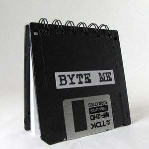 May include: Black floppy disk notebook with a silver label that says "TDK MF-2HD IBM/DOS FORMATTED" and a white label that says "BYTE ME".