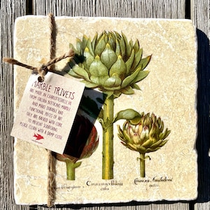 May include: A set of four marble coasters with a botanical illustration of artichokes. The coasters are backed with cork to prevent scratching and are made in Charlottesville, VA from Italian Botticino marble. The text on the coasters reads "Marble Trivets Are Made in Charlottesville, VA From Italian Botticino Marble And Make Durable And Functional Pieces Of Art They Are Backed With Cork To Prevent Scratching Please Clean With A Damp Cloth www.etsy.com/shop/winfrey", "british："A set of four marble coasters featuring a botanical illustration of artichokes. The coasters are backed with cork to prevent scratching and are made in Charlottesville, VA from Italian Botticino marble. The text on the coasters reads "Marble Trivets Are Made in Charlottesville, VA From Italian Botticino Marble And Make Durable And Functional Pieces Of Art They Are Backed With Cork To Prevent Scratching Please Clean With A Damp Cloth www.etsy.com/shop/winfrey", "french":