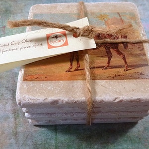 May include: Set of four square stone coasters with a vintage image of a camel printed on each. The coasters are tied together with twine and a tag that reads "The Works by Cary".