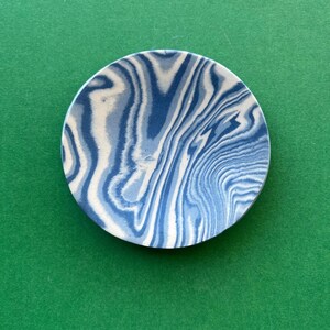 May include: A blue and white swirl ceramic dish. The dish has a marbled pattern with blue and white swirls.