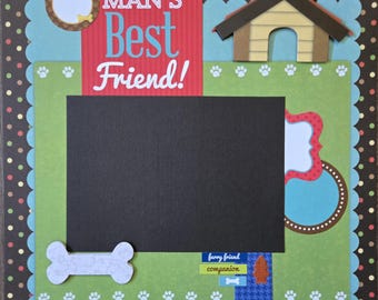 May include: A scrapbook page with a dog theme. It features a large black rectangle for a photo, surrounded by green and blue scalloped edges. Text reads "MAN'S Best Friend!" and includes a dog bone and paw prints.