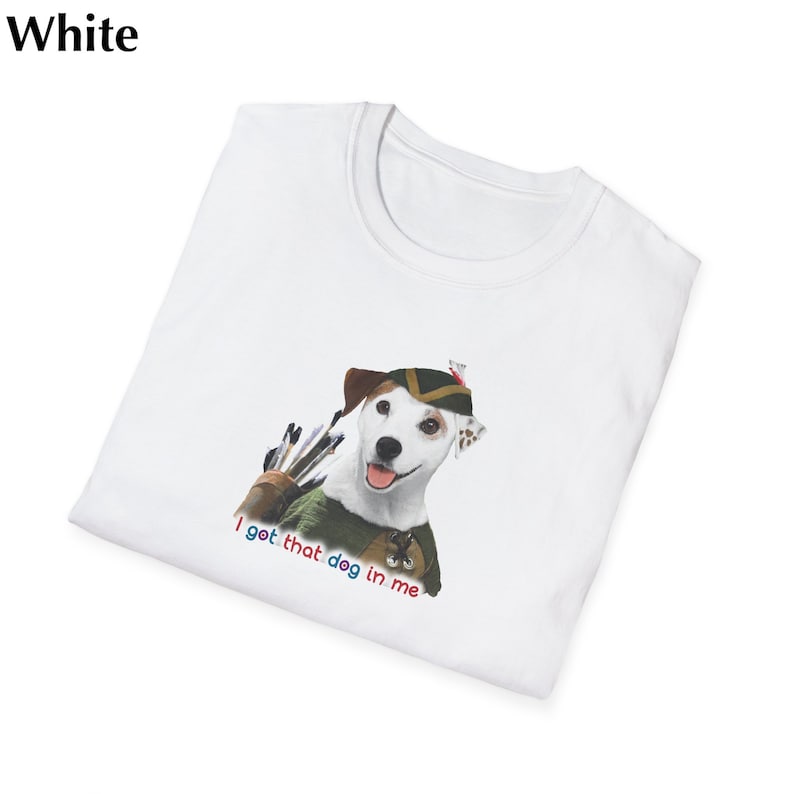 May include: White t-shirt featuring a cartoon dog dressed as an archer with a quiver of arrows. The dog wears a green and brown hat and vest. The text "I got that dog in me" is printed below the dog in red, blue, and green.