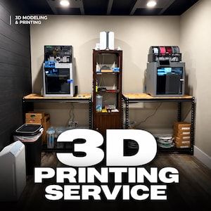 May include: Two gray 3D printers sit on black metal shelving units with wooden surfaces. A tall brown wooden cabinet stands between them. The text 3D MODELING & PRINTING appears in the top left, and 3D PRINTING SERVICE is in large white letters.