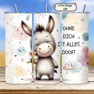 May include: A white tumbler featuring a cartoon donkey holding a flower. The donkey has a smiling face and the text "OHNE DICH IST ALLES DOOF!" is printed on the side. The tumbler has a stainless steel straw.