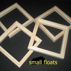 May include: Four unfinished wooden picture frames of various sizes, stacked on top of each other. The frames are all square and have a simple, unadorned design. The text "small floats" is written below the frames.