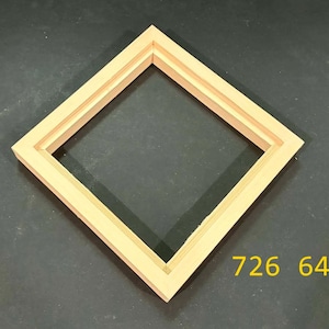 May include: A square, light-colored wooden picture frame oriented as a diamond. The frame features a stepped, multi-layered profile with a natural wood grain finish. The numbers 726 64 are printed in yellow in the bottom right corner of the image.