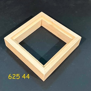 May include: A square wooden frame with a light natural wood grain finish and a recessed inner edge. The frame features mitered corners and a clean, simple construction. The yellow text 625 44 is printed in the lower left corner of the image.