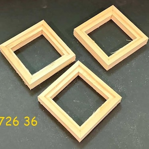 May include: Three square, light-colored wooden frames with beveled inner edges arranged in a triangular formation. The frames are unfinished, showing natural wood grain. The yellow text 726 36 is visible in the lower left corner of the image.