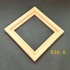 May include: A square wooden picture frame with a light natural finish, positioned at a diamond angle. The frame features mitered corners and a stepped inner edge profile. The yellow text 826 6 is visible in the lower right corner of the image.