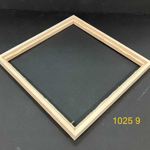 May include: A square, unfinished wooden frame with a black interior. The frame is made of light-colored wood and has a double-layered design. The number "1025 9" is printed in yellow in the lower right corner.
