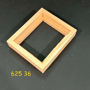 May include: A rectangular wooden frame with mitered corners and a natural light brown finish. The frame has a stepped profile and is positioned at an angle. The yellow text 625 36 is printed in the lower left corner of the image area.
