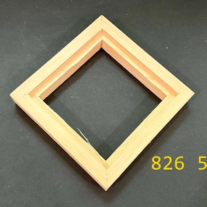 May include: A square wooden frame with a light tan natural finish, positioned in a diamond orientation. The frame features a stepped inner edge profile and mitered corners. The yellow text 826 5 is visible in the lower right corner of the image.