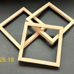 May include: Three square wooden frames with a light natural finish, arranged in an overlapping pattern. The frames feature mitered corners and a simple, flat profile. The yellow text 926 19 is visible in the lower left corner of the image.