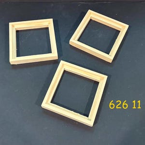 May include: Three square, light-colored wooden frames with a smooth finish and a simple, flat profile. The frames are arranged in a triangular formation. The yellow text 626 11 is visible in the lower right corner of the image.