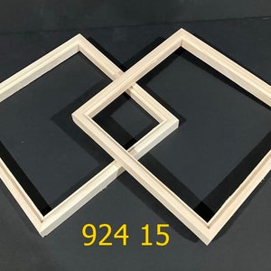 May include: Two light-colored wooden picture frames arranged in an overlapping diamond pattern. The frames are empty and have a simple, clean profile. The yellow text 924 15 is visible at the bottom center of the image, positioned below the frames.