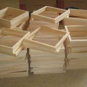 May include: A stack of unfinished wooden picture frames, ready to be painted or stained. The frames are all the same size and are made of natural wood.