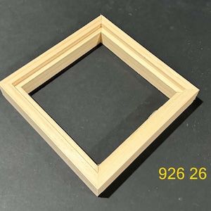 May include: A square wooden floating frame with a light natural wood grain finish and a recessed inner edge for mounting canvas. The frame features mitered corners and the yellow text 926 26 is printed in the bottom right corner of the image.