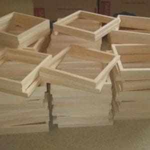 May include: A large collection of square, unfinished light-colored wooden frames stacked in multiple piles. Each frame features a simple, clean-edged construction with visible natural wood grain, designed for mounting canvas or other flat materials.