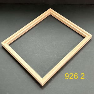 May include: A rectangular light-colored wooden picture frame with a stepped profile and mitered corners. The frame is empty and features a natural wood grain finish. The yellow text 926 2 is visible in the bottom right corner of the image.