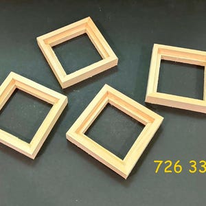 May include: Four square light-colored wooden frames with a natural finish and a hollow center. The frames are arranged in a scattered pattern. The yellow text 726 33 is visible in the lower right corner of the image, indicating a product code.