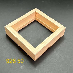 May include: A square wooden frame with a light tan natural finish and mitered corners. The frame features a recessed inner edge for mounting. The text 926 50 is displayed in yellow in the lower left corner of the image, providing a clear identifier.