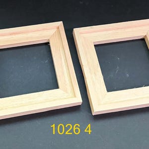 May include: Two square, unfinished light-colored wooden frames with mitered corners and a beveled inner edge. The frames are positioned side-by-side, and the yellow text 1026 4 is visible at the bottom center of the image.