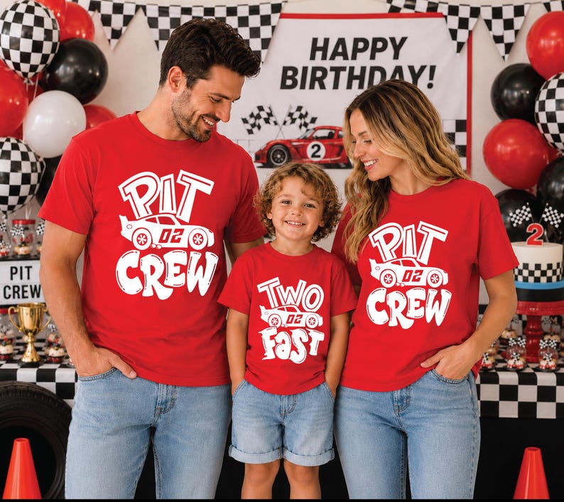 May include: Three red short-sleeve t-shirts featuring white graphic prints. Two shirts display the text PIT CREW with a race car graphic, while the smaller shirt displays the text TWO FAST with a race car graphic, all in a bold, stylized font.