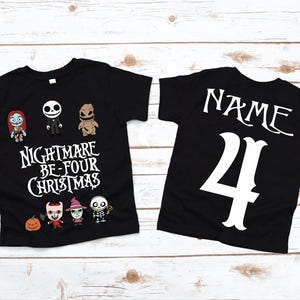 May include: Black t-shirts with a Nightmare Before Christmas theme. The front shirt features characters and text that reads "Nightmare Be-Four Christmas". The back of the shirt has the word "Name" and the number "4".
